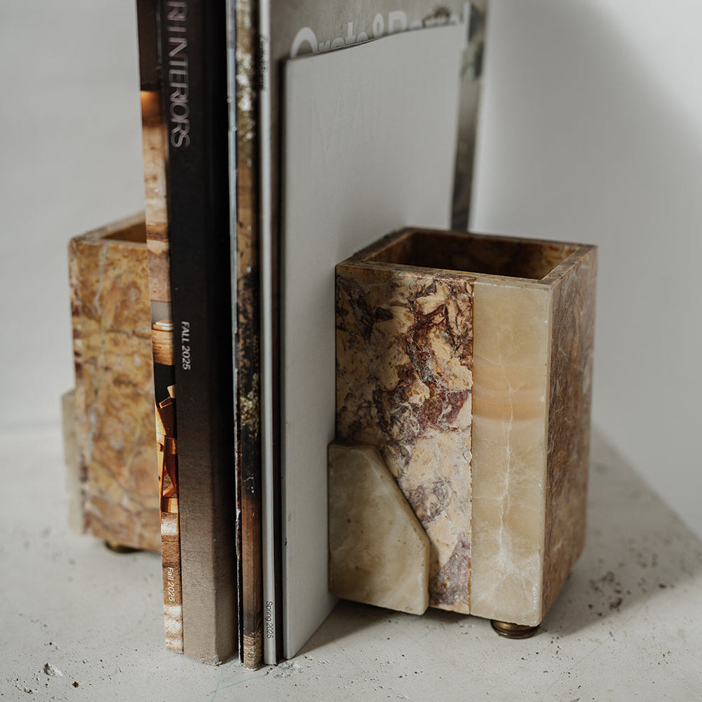 Decorative stone bookends with brass feet holding books