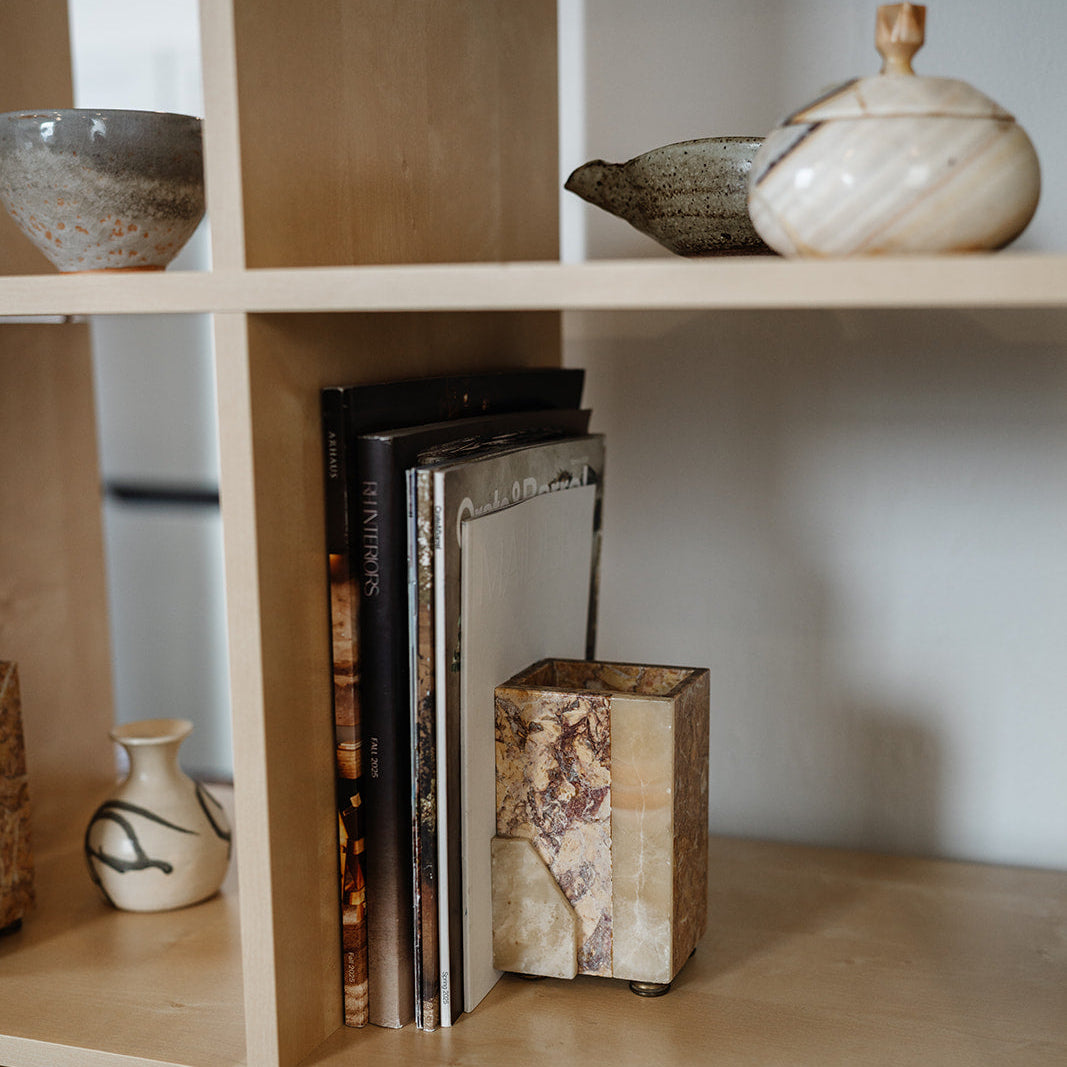 Decorative stone bookends with brass feet holding books